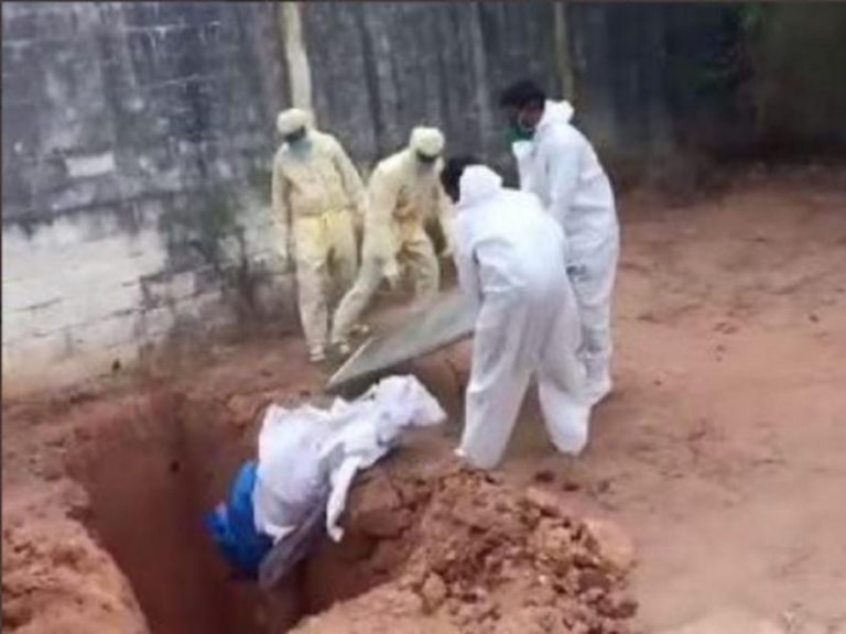 Workers throwing the body of a COVID-19 positive man into a pit in Puducherry