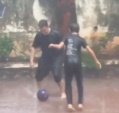 Kicker: Aamir enjoys playing football with son Azad in the rain